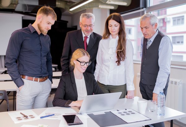 Equipo empresarial multidisciplinar revisando con asombro los resultados de un sistema Agentic RAG en una laptop en oficina moderna