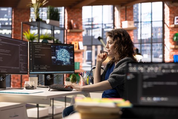 Equipo de desarrollo analizando la integración organizativa de IA en su sistema de trabajo con diagramas de proceso y métricas