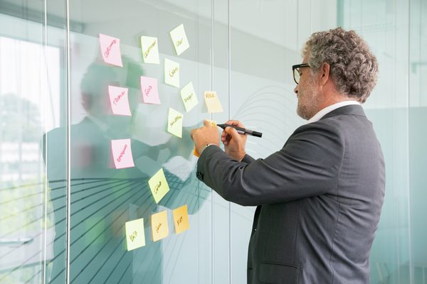 Equipo de liderazgo técnico analizando prioridades en pizarra con matriz de decisión y roadmap estratégico